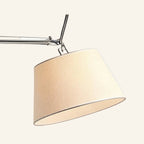Close-up of the tapered ivory fabric shade and articulated polished aluminum joint showing pivot hardware and woven textile texture.