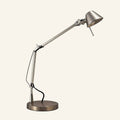 Silver aluminum swing arm desk lamp with conical shade, counterweight cable, and weighted disc base on cream backdrop