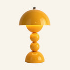 Mustard yellow mushroom table lamp with chrome finial and stacked sphere stem, glossy ABS body shown lit on a neutral studio background