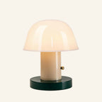 Green base and cream stem version of the cordless table lamp with glowing opal glass dome and brass touch button