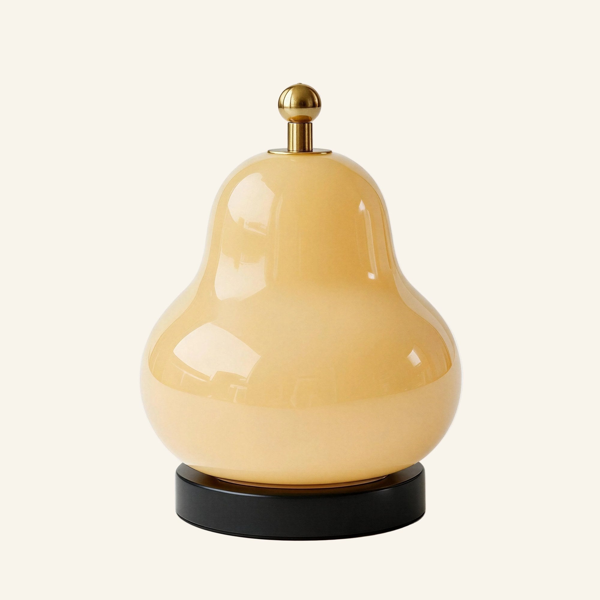 Pear-shaped cream glass table lamp with brass touch-dimmer finial and black cylindrical base, shown on a soft cream studio backdrop