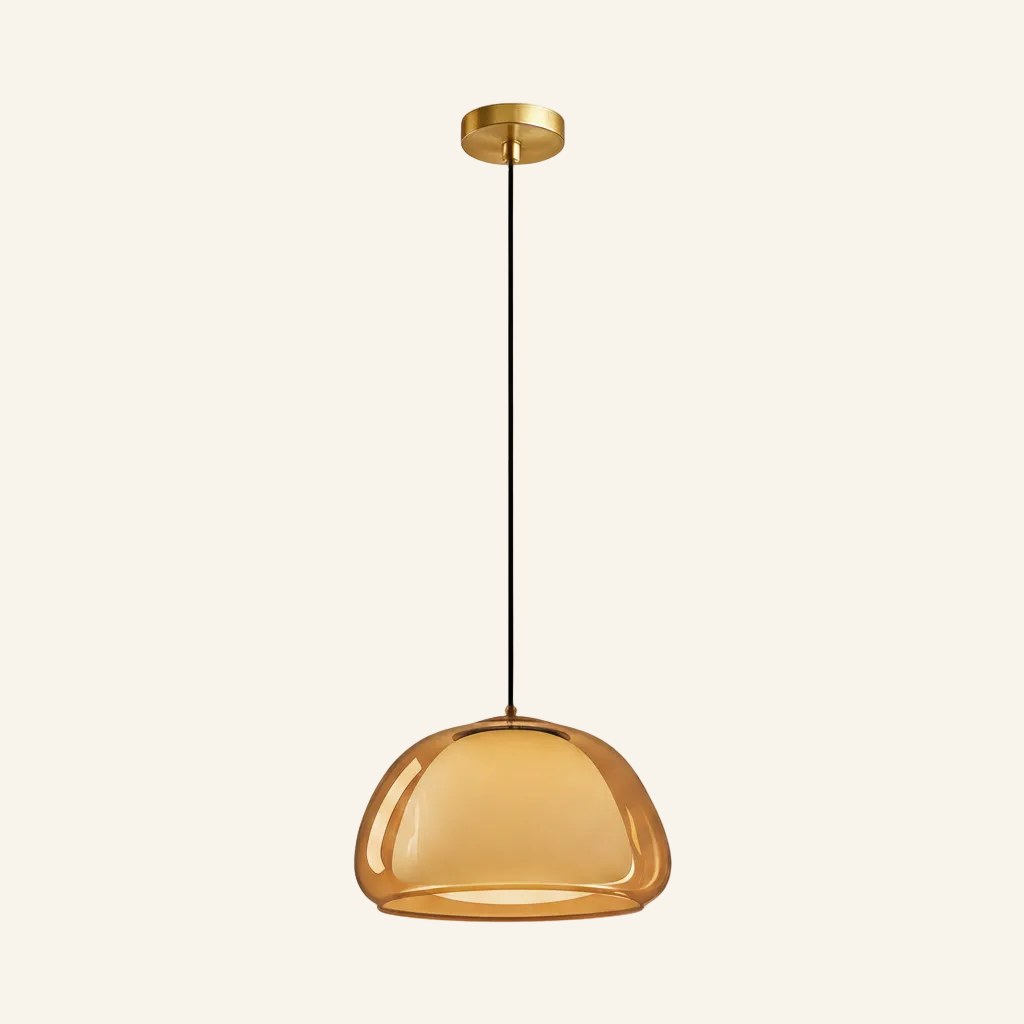 Amber-tinted variant of the dome pendant glowing softly, showing the rounded outer glass and inner diffuser on neutral background