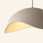 Close-up of the matte sand-white shade showing fine textured finish and curved cutout rim diffusing warm LED light into the interior cavity.