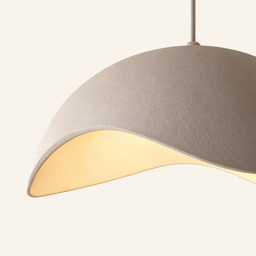 Close-up of the matte sand-white shade showing fine textured finish and curved cutout rim diffusing warm LED light into the interior cavity.