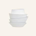 Stacked matt-white iron shells form a tiered petal sconce on cream backdrop, sculptural wall light with overlapping curved layers