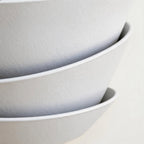Close-up of overlapping matt-white iron petals showing fine textured finish and thin rolled edges of the layered shell wall sconce
