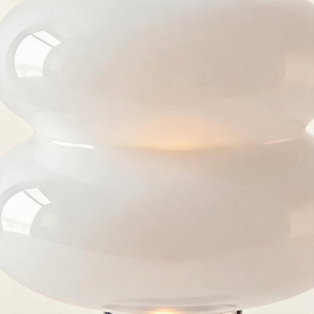 Close-up of glossy opal glass double-disc shade glowing warm at the seam, showing smooth reflections and milky diffusion