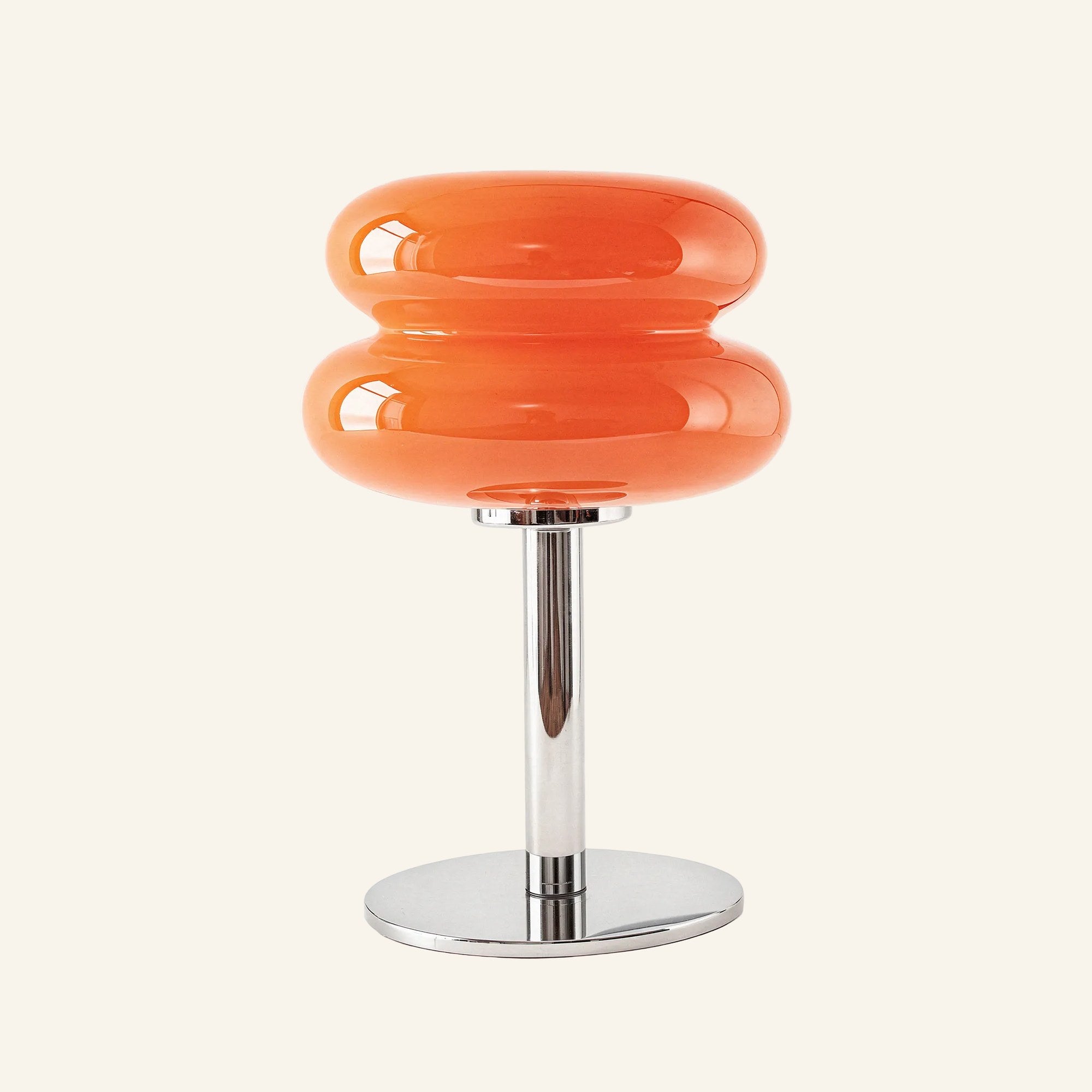 Bright orange stacked opal glass shade on polished chrome stand, bold retro-leaning table lamp shown straight-on for color reference