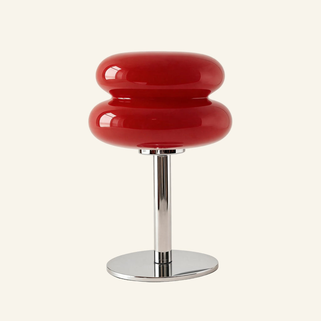 Deep red glossy glass macaron shade on mirrored chrome stem and round base, accent table lamp photographed against off-white background
