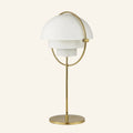 White twin hemispherical shades pivot inside a polished brass ring above a slim stem and disc base, mid-century table lamp on cream backdrop.