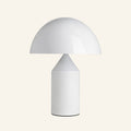 Glossy white mushroom dome table lamp with cylindrical metal base and inner cone reflector on cream studio backdrop