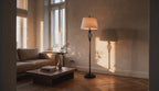 Cinematic video of a black metal floor lamp with twisted cage column and white drum shade casting warm shadows in a sunlit living room.