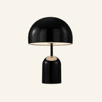 Black gloss version of the dome table lamp on cream background, mirrored shade hovering over a rounded cylindrical metal base