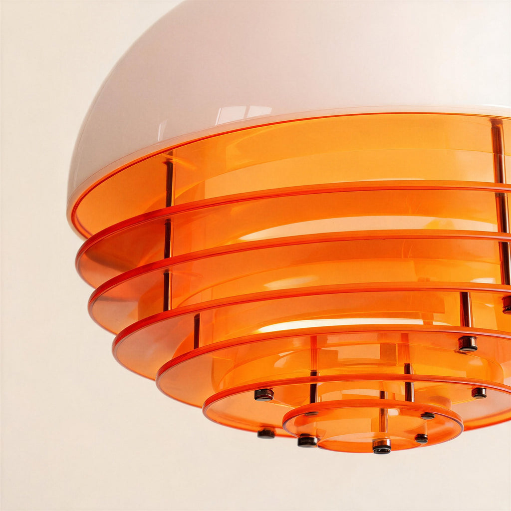 Close-up of the pendant's underside showing layered orange acrylic discs joined by small chrome bolts beneath the glossy white glass shade.