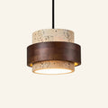 Two-tier travertine pendant lamp banded by a dark walnut wood ring, suspended from a black cord against a cream studio backdrop.
