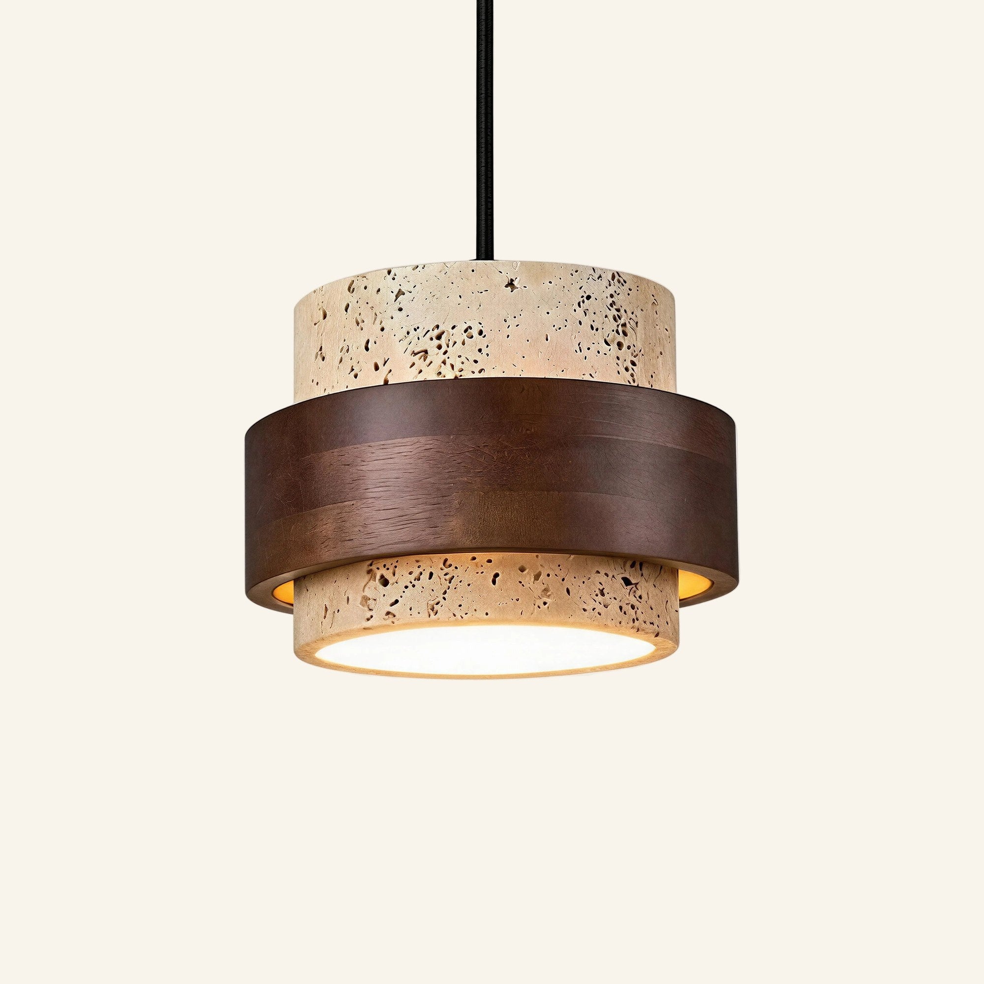 Two-tier travertine pendant lamp banded by a dark walnut wood ring, suspended from a black cord against a cream studio backdrop.