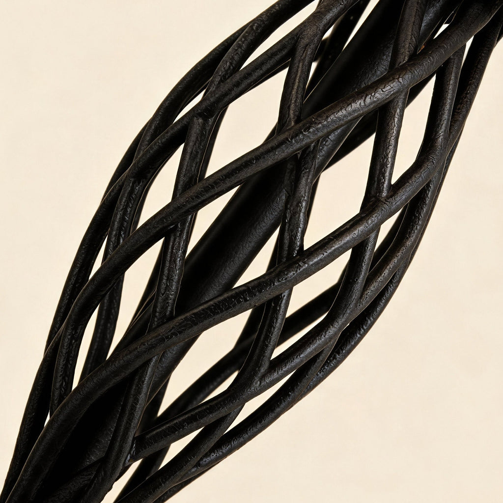 Close-up of the twisted open-cage iron column showing intertwined black metal bars and rough hand-finished surface.