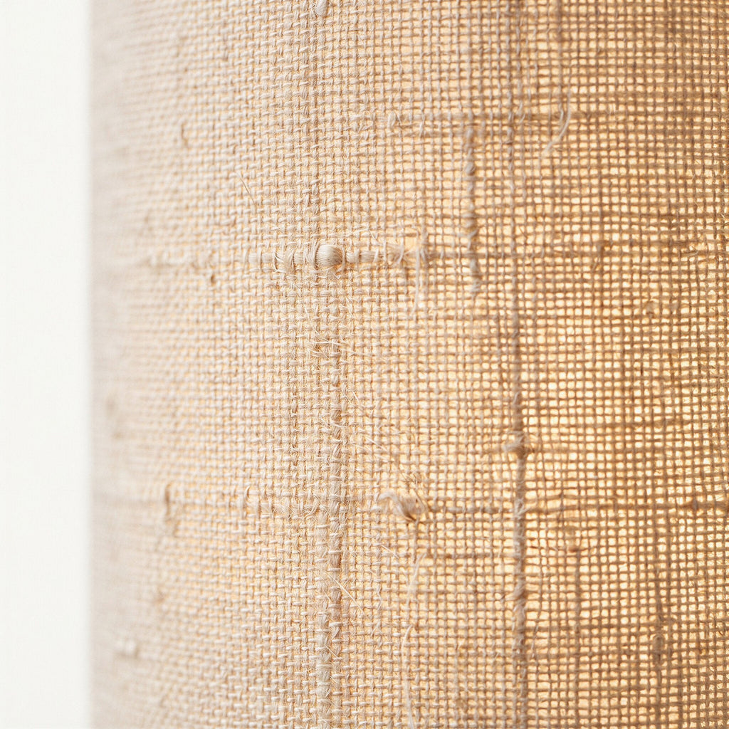 Close-up of the natural beige linen fabric shade revealing its open weave and visible woven seams.